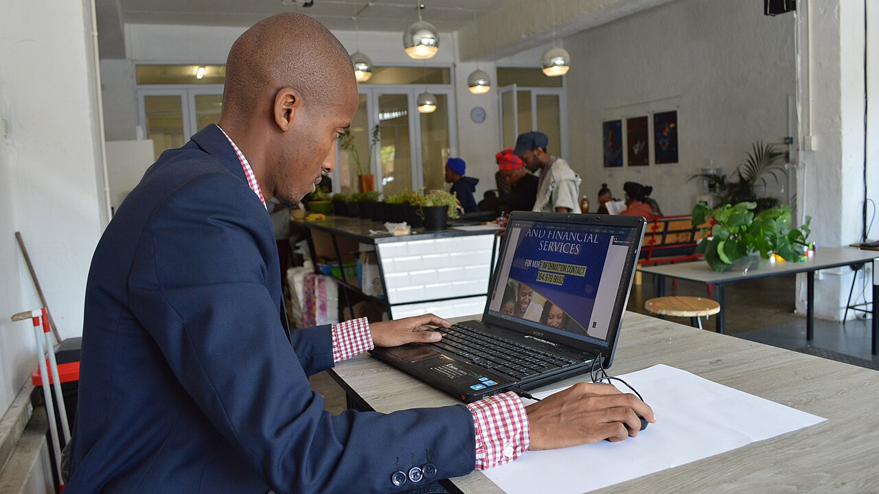 A graphic designer working at a dual-screen computer setup