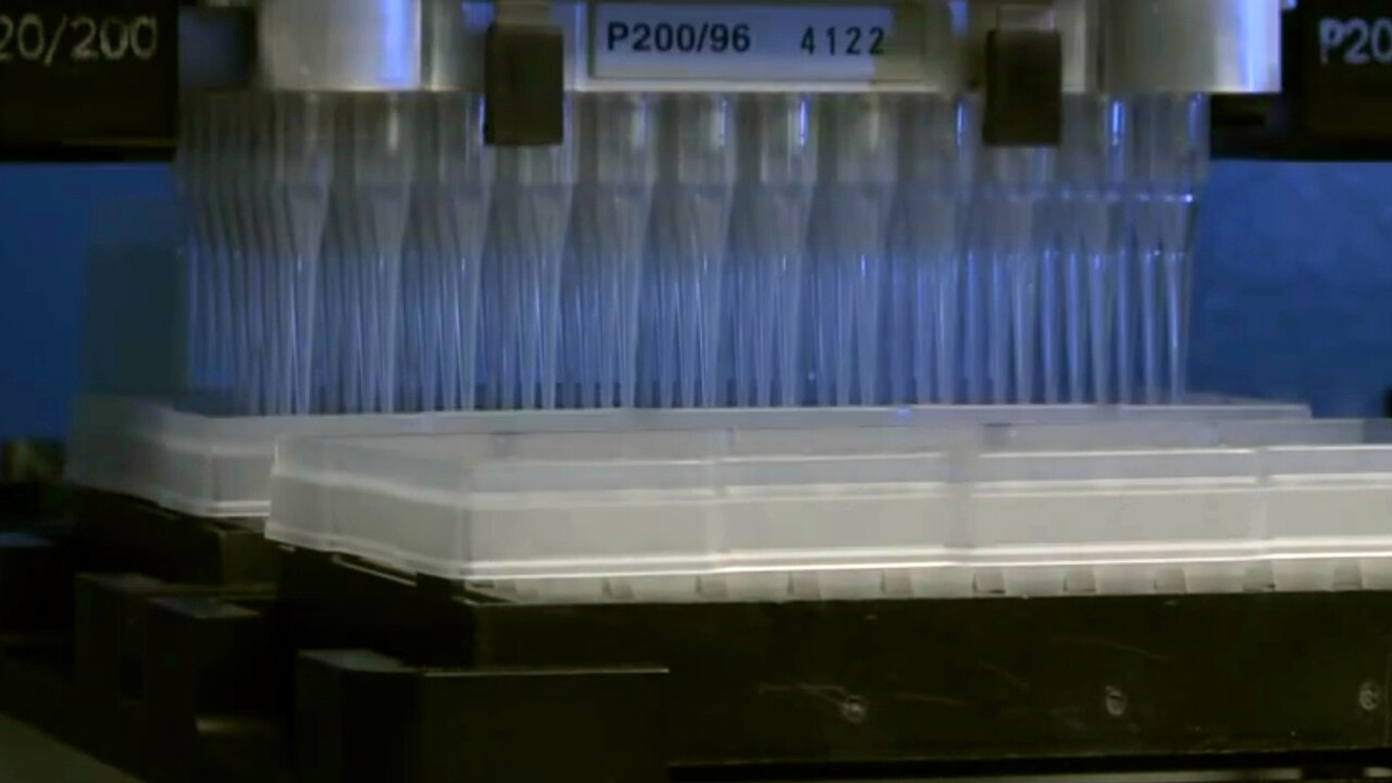 Dual-arm laboratory liquid-handling robot manipulating assay plates