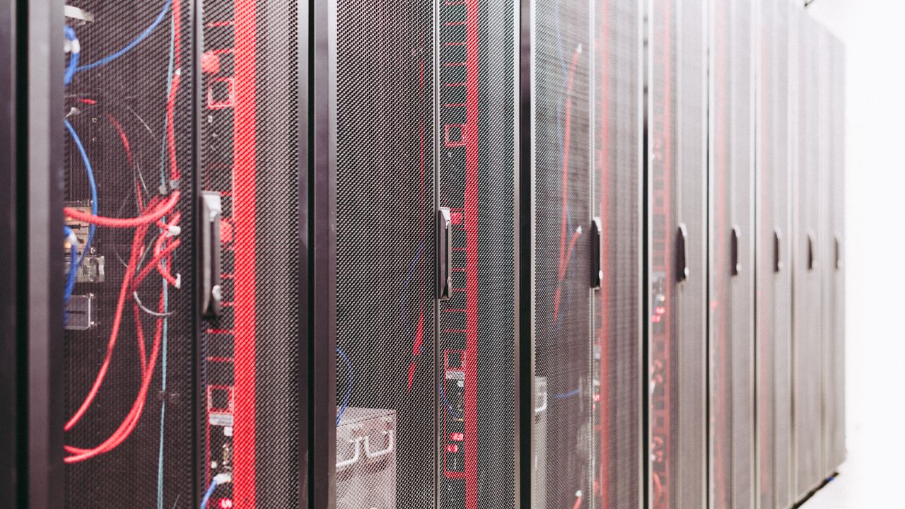 Rows of server racks with network cables in a data center